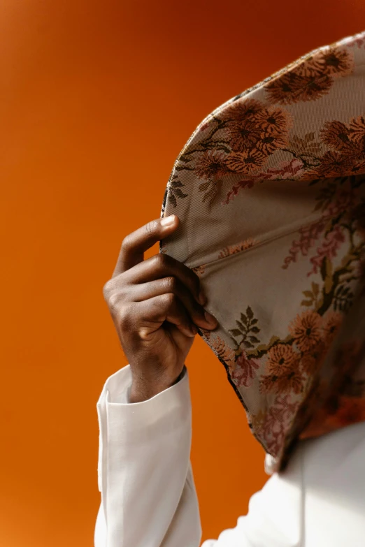 a close up of a person holding an umbrella, head scarf, orange skin. intricate, floral, slide show