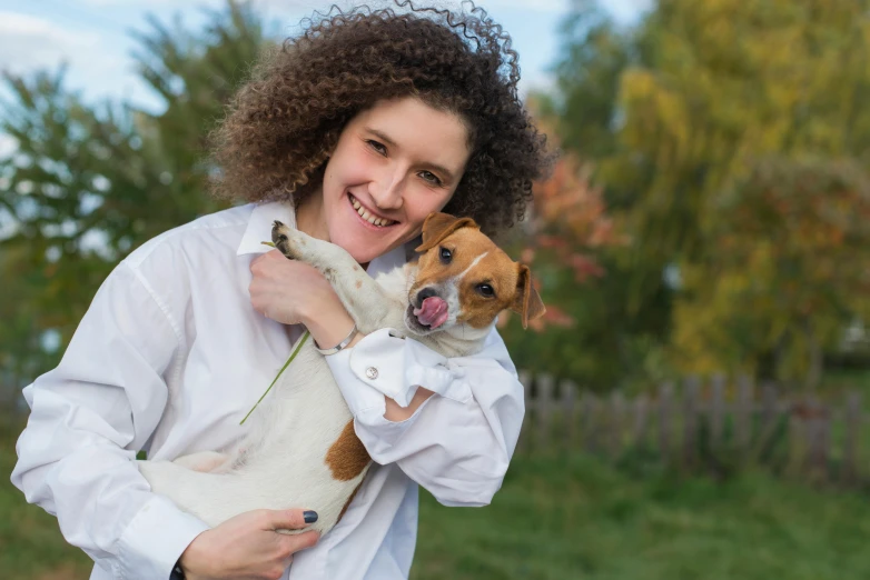 a woman holding a small dog in her arms, by Julia Pishtar, pixabay contest winner, wearing lab coat and a blouse, having a good time, nadezhda tikhomirova, thumbnail