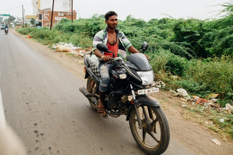 a man riding on the back of a motorcycle down a road, samikshavad, portrait photo, 15081959 21121991 01012000 4k, beaten, sturdy body
