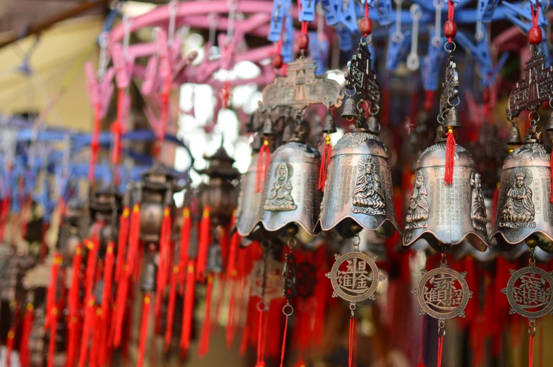 a bunch of bells hanging from a ceiling, inspired by Ai Weiwei, pexels, cloisonnism, pagoda with a lot of wind chimes, 🦩🪐🐞👩🏻🦳, market stalls, thumbnail