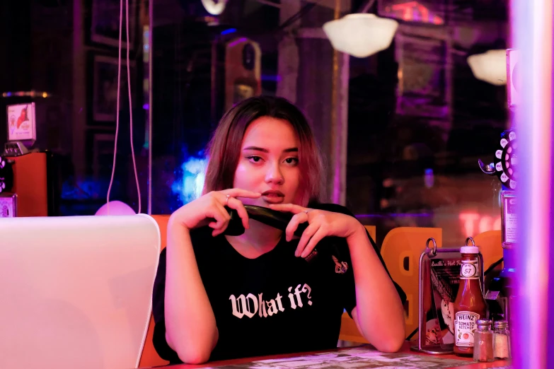 a woman sitting at a table in front of a laptop, pexels contest winner, realism, with neon signs, wearing black tshirt, ( waitress ) girl, quy ho