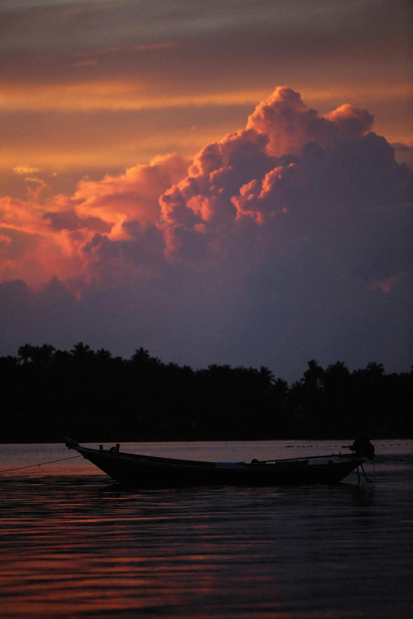 a boat that is sitting in the water, inspired by Steve McCurry, flickr, sumatraism, pink storm clouds, silhouetted, a handsome, resting