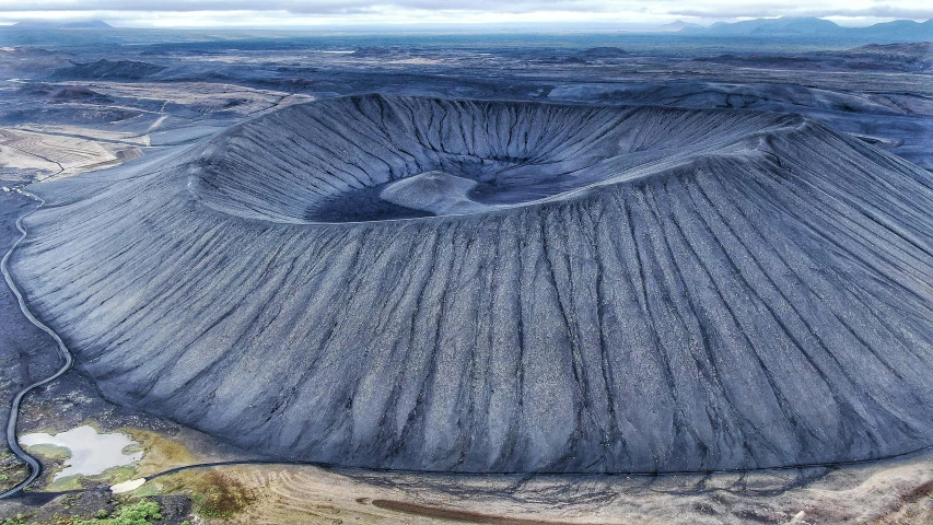 a large crater surrounded by mountains and a body of water