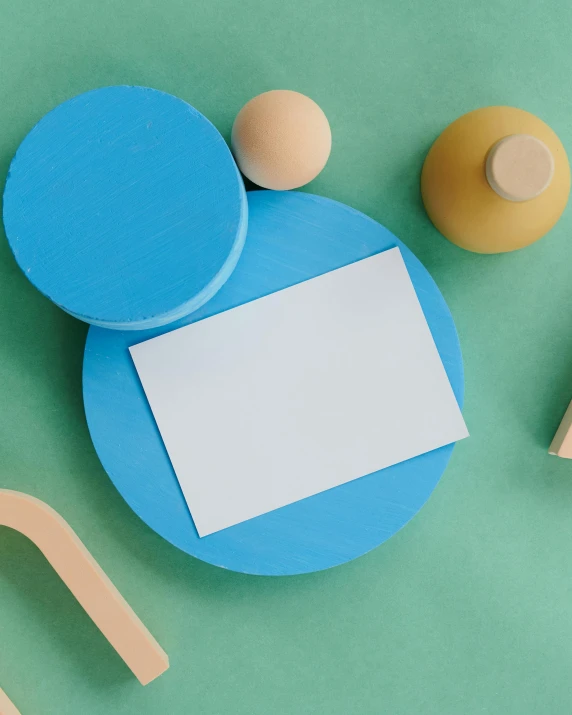 a blue plate sitting on top of a green table, an abstract sculpture, inspired by Malevich, pexels contest winner, card template, wooden art toys, thumbnail, whiteboards