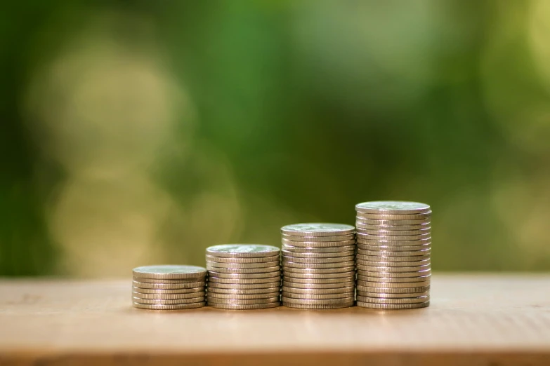 a stack of coins sitting on top of a wooden table, from a distance, promo image, a green, multiple levels