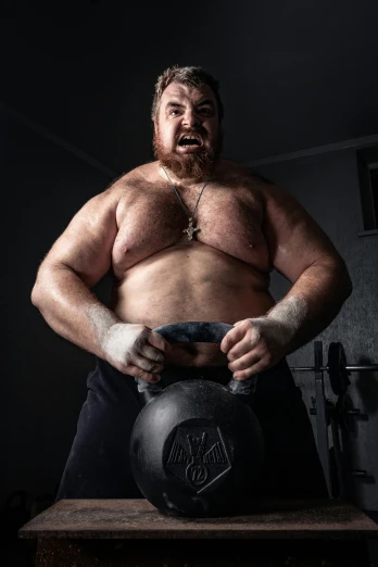 a man holding a kettle on top of a wooden table, an album cover, by Ilya Ostroukhov, reddit, muscular! crossfit, action bronson, profile picture 1024px, angry man