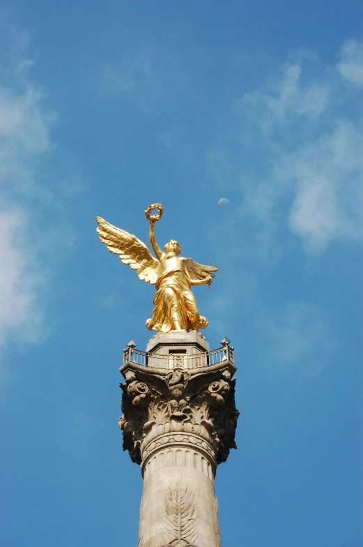 a statue of an angel on top of a column, pexels contest winner, berlin secession, downtown mexico, wearing a golden halo, taken in the late 2000s, square