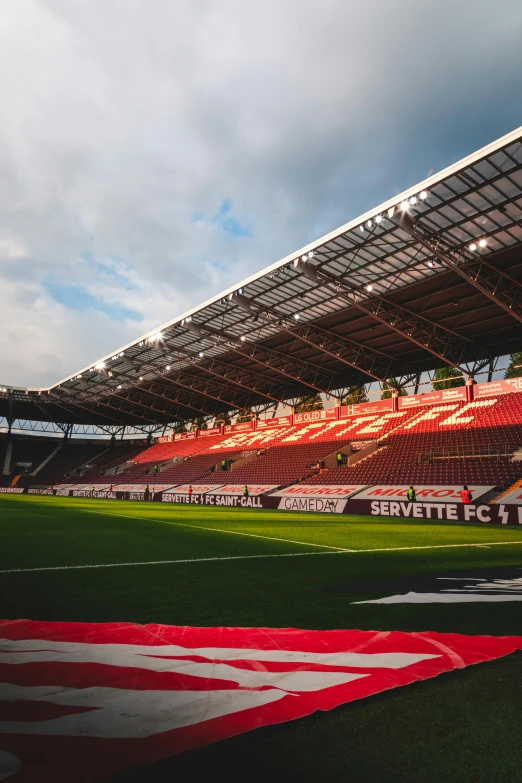 a soccer stadium with an american flag on the field, a picture, happening, liege, crimson themed, turf roof, sunlit