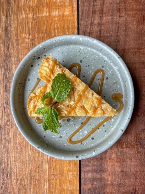 a piece of pie on a plate on a wooden table, shot on iphone 1 3 pro max, stroopwaffel, mint, detailed product image