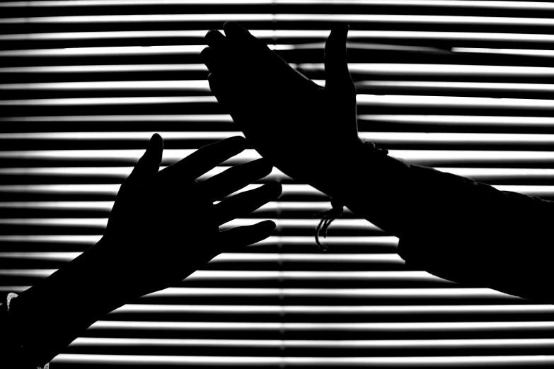 a silhouette of a person holding a pair of scissors, a black and white photo, purism, shaking hands, soft light through blinds, photo illustration, billboard image