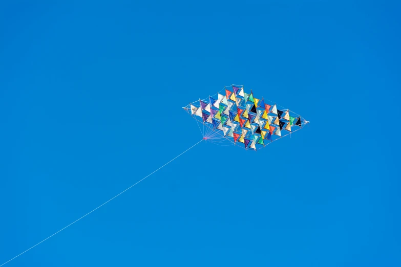 a kite that is flying in the sky, an album cover, by Matthias Weischer, pexels contest winner, kinetic art, cloudless blue sky, ignant, lattice, tatsuro kiuchi