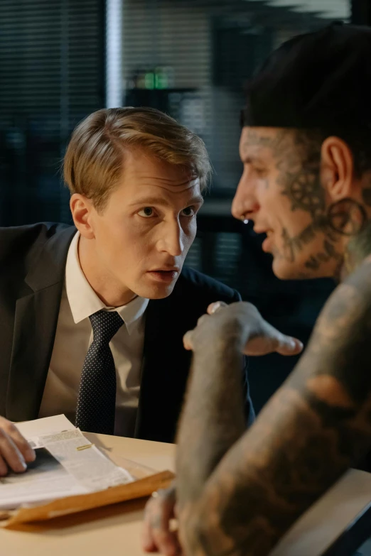 two men sitting at a table talking to each other, a tattoo, lawyer suit, subsurface scandering, ( ( theatrical ) ), bbc