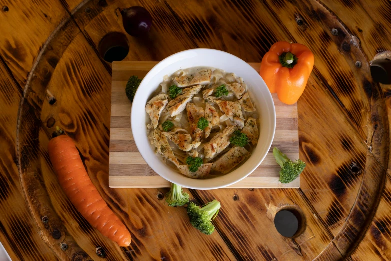 a bowl of food sitting on top of a wooden table, chicken, caparisons, profile image, frontal shot