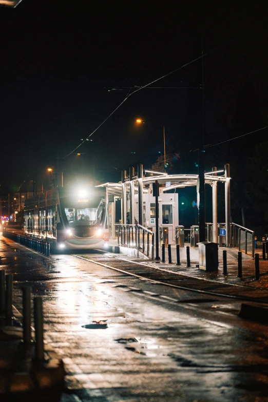 a train pulls up to the station at night