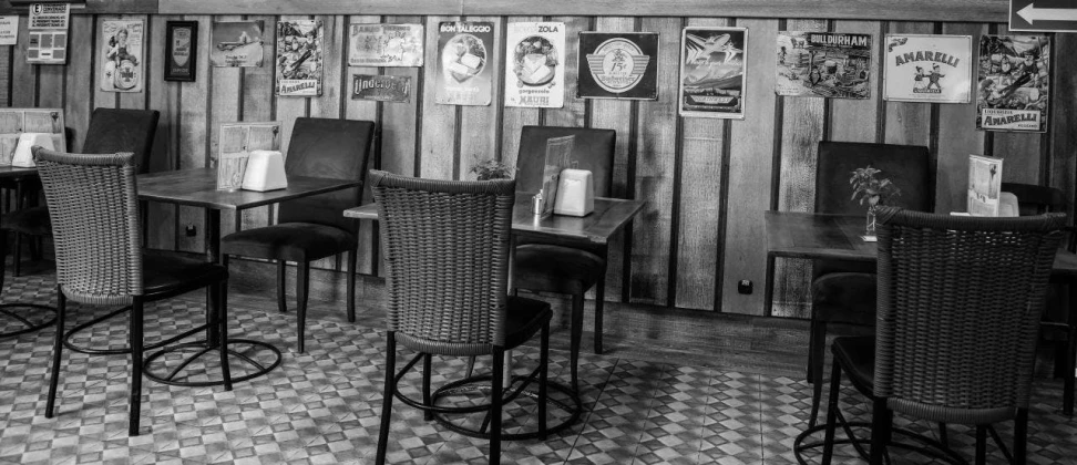 a black and white photo of a restaurant, fine art, posters on the wall, sittin, old style photo