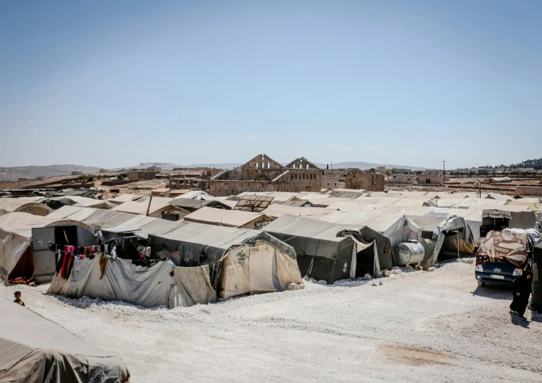 a group of tents sitting on top of a dirt field, by Tobias Stimmer, hurufiyya, poor buildings, profile image, conde nast traveler photo, aida muluneh