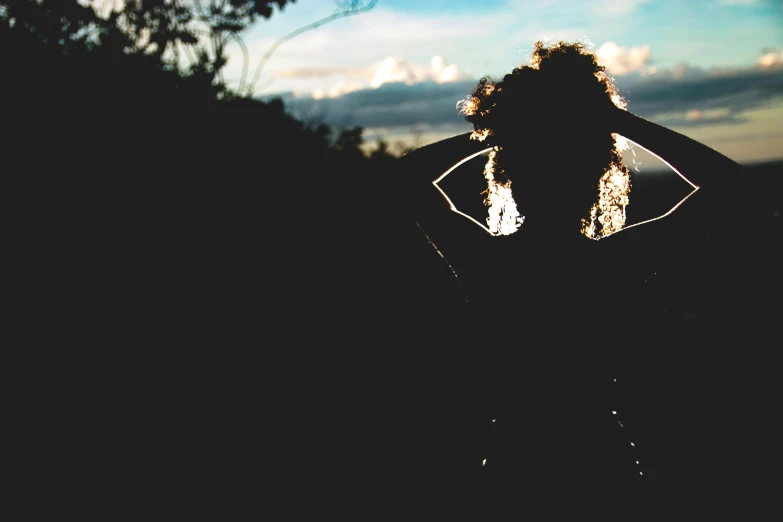 a silhouette of a person holding a surfboard, an album cover, by Lucia Peka, unsplash, back light, profile image, woman in a dark forest, frayed edges. light leaks