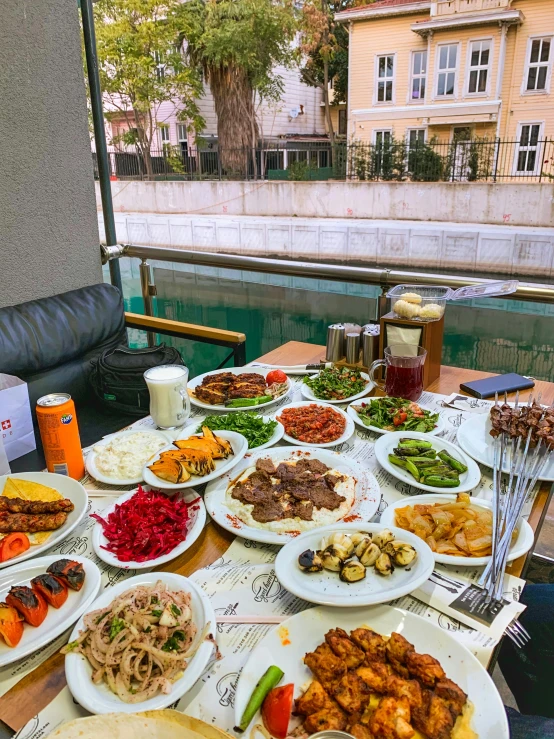 an array of plates of food sitting on a table outside