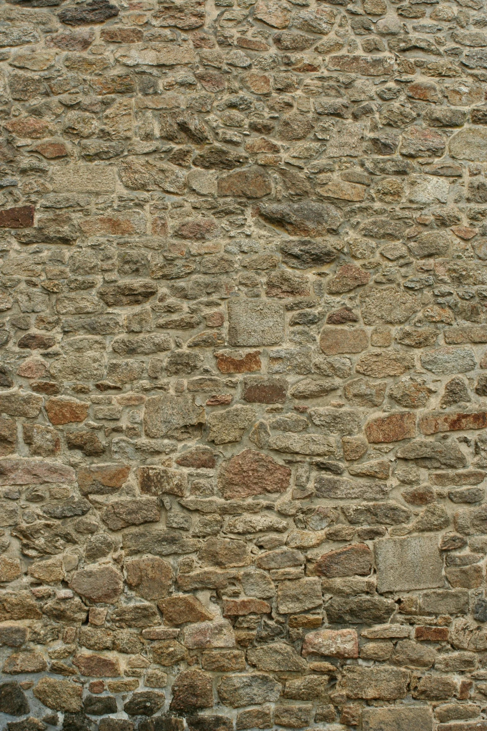 a yellow bird stands alone on top of a stone wall