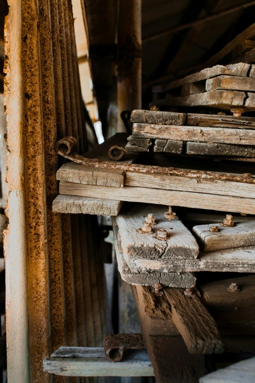 a pile of wood sitting on top of a wooden floor, a portrait, unsplash, assemblage, rusty metal towers, steel mill, profile image, shelves full of medieval goods