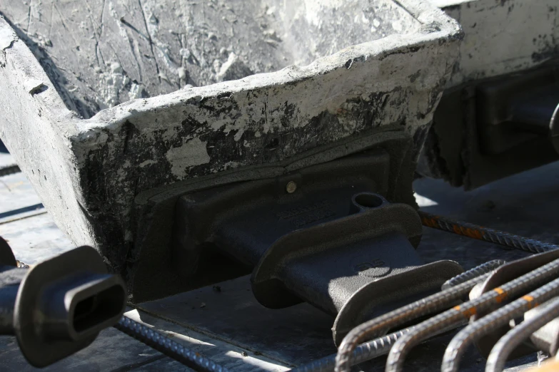 a boat sitting on top of a wooden dock, concrete art, coal dust, cast iron material, neck zoomed in, titanium