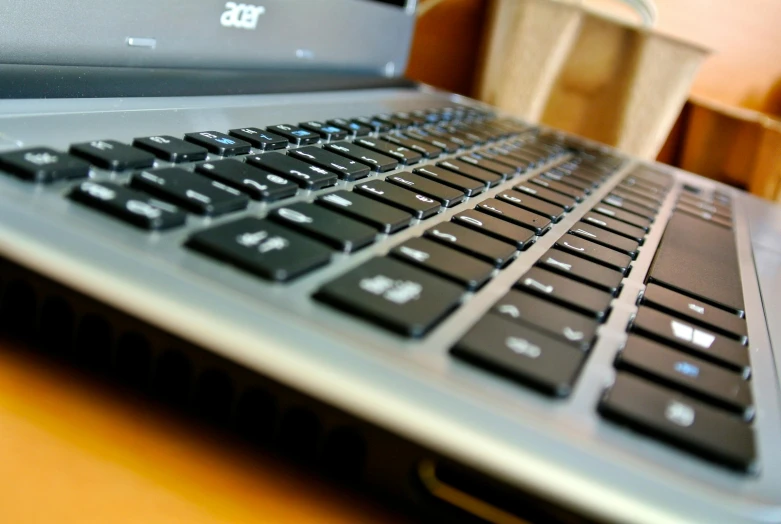 a laptop computer sitting on top of a wooden desk, by Carey Morris, pixabay, shot from a low angle, keyboards, bumps, photo illustration