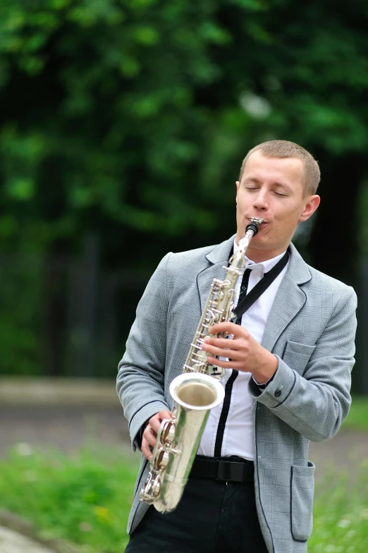 a man with a band playing saxophone on a sidewalk