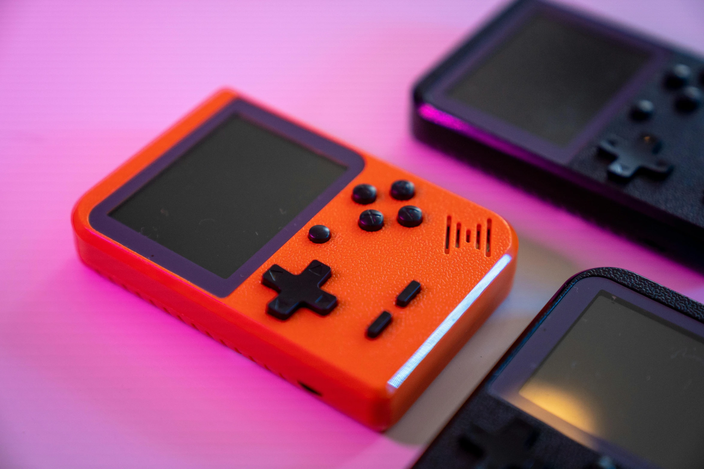 a couple of game controllers sitting next to each other, a low poly render, by Joe Bowler, unsplash, pixel art, orange red black white, game case, conway's game of life, medium close-up shot