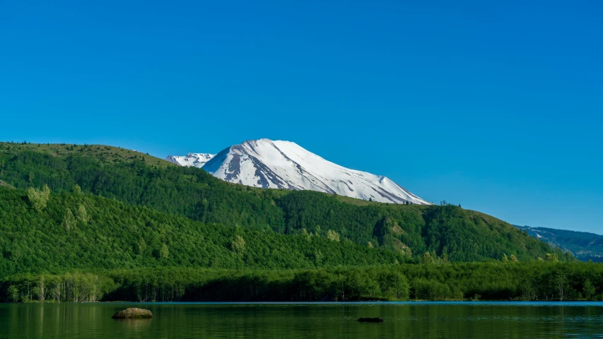 snow capped mountain rising above a body of water