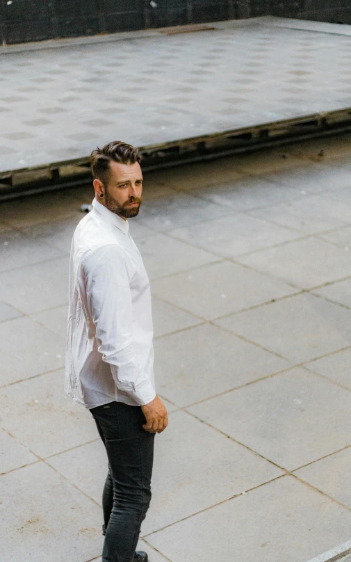 the man is standing on his skateboard near concrete