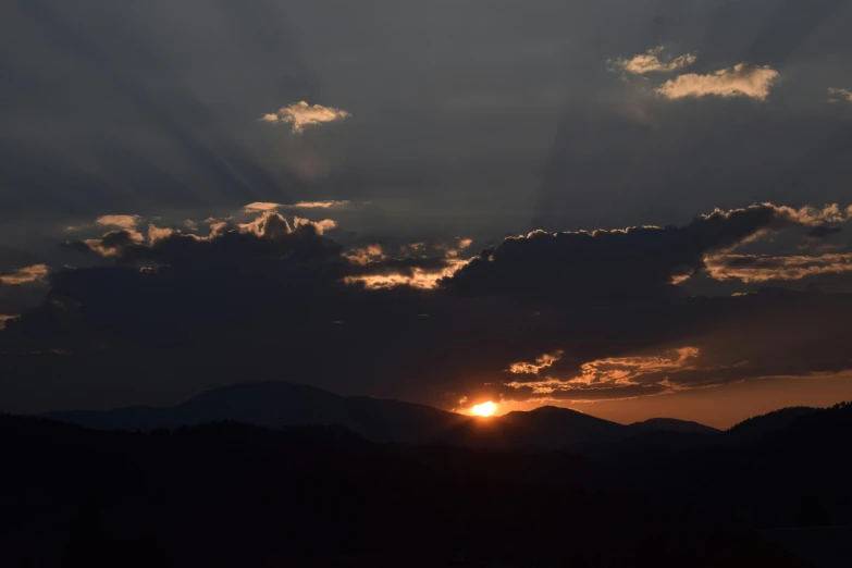 the sun is setting behind the clouds over the mountains, by Mirko Rački, pexels contest winner, romanticism, sun shaft, ((sunset)), summer evening, zoomed out