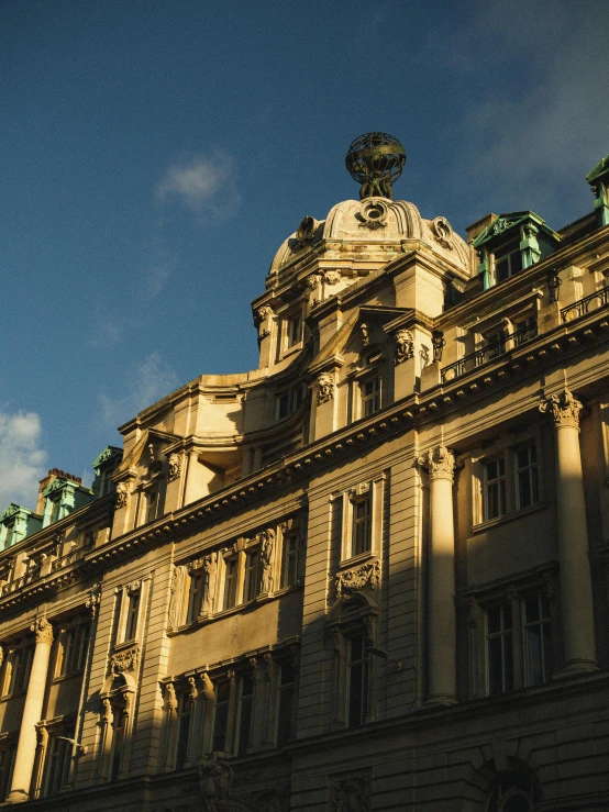 a large building with a clock on top of it, in the golden hour, broadway, london architecture, golden hour photograph