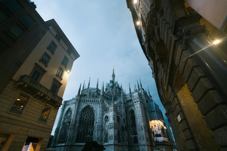 tall buildings and an illuminated cathedral on a cloudy day