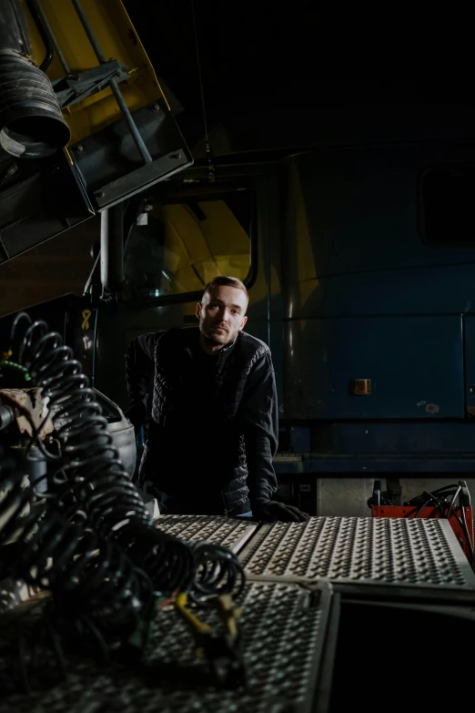 a man standing next to a machine in a factory, a portrait, pexels contest winner, arbeitsrat für kunst, against dark background, driver, sweden, profile picture