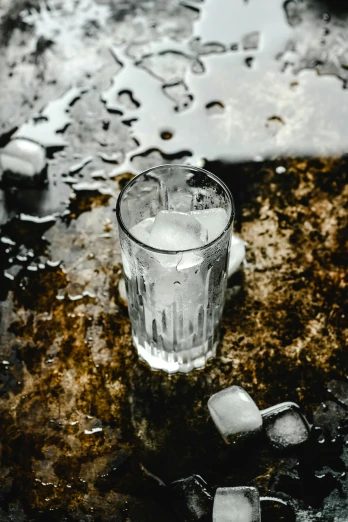 an ice and water glass sitting on top of the ground