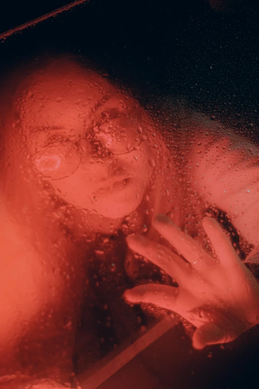 a close up of a person looking through a window, inspired by Elsa Bleda, pexels contest winner, holography, cover with a lot of red water, portrait of a woman underwater, found footage style, freezing