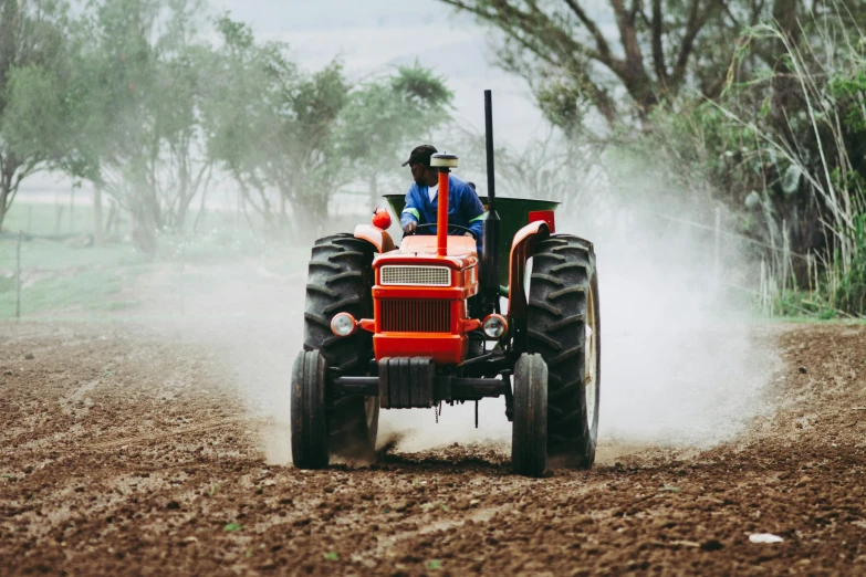 a man riding on the back of a red tractor, pexels contest winner, green gas spreading across land, avatar image, schools, irrigation