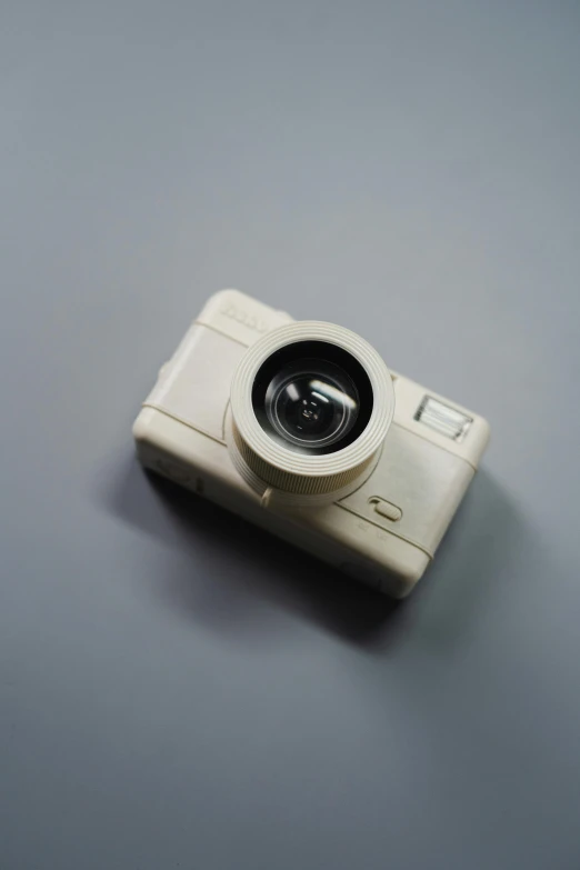 a white camera sitting on top of a table, by Shigeru Aoki, 3 d print, late 2000’s, dji top down view, front view 2 0 0 0