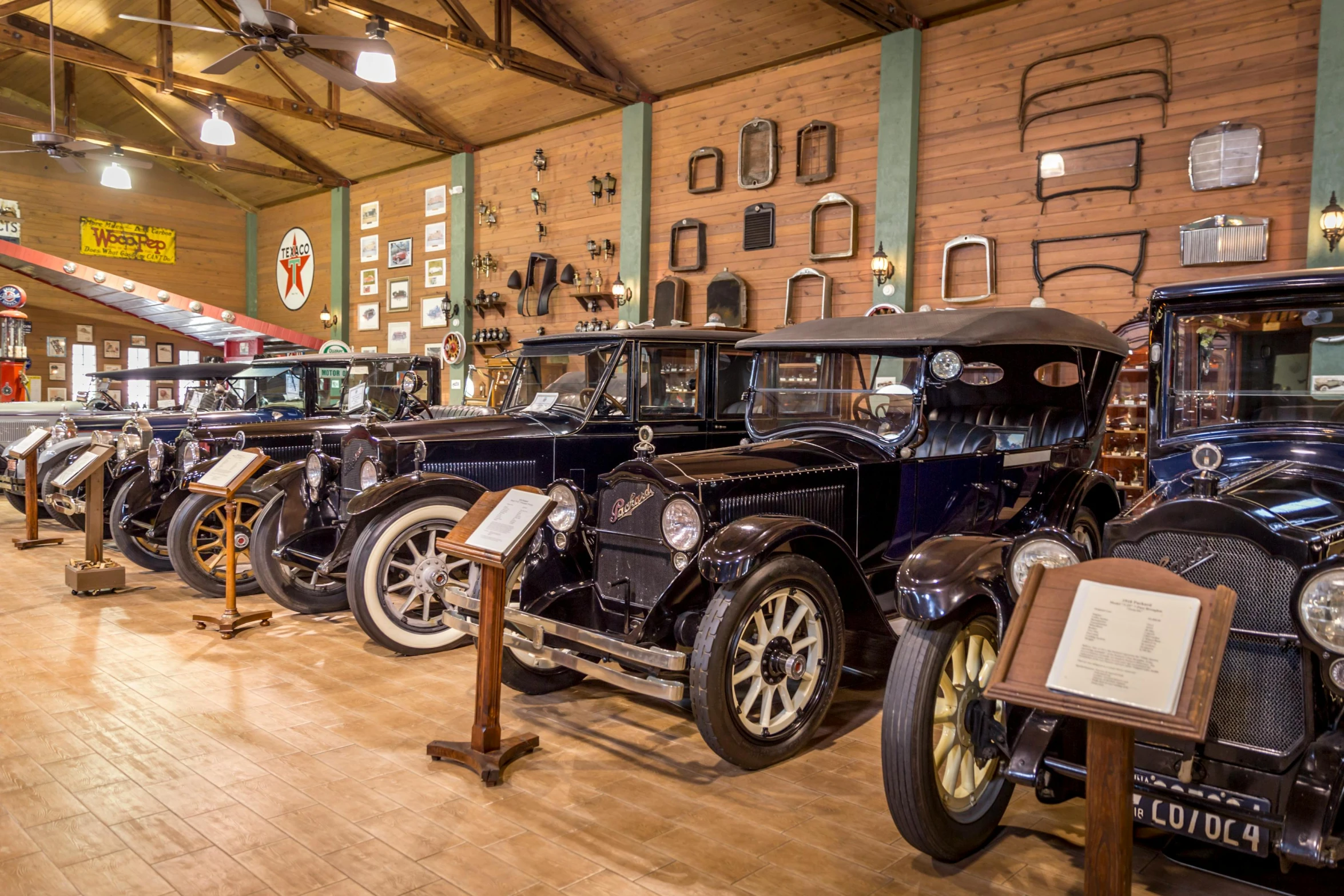 a row of antique cars on display in a museum, by Jessie Algie, wide shot of a cabin interior, official store photo, thumbnail, various posed