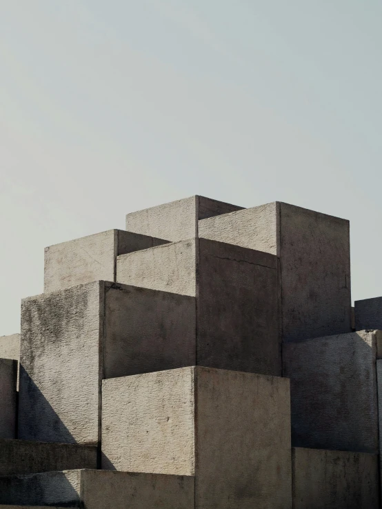 a group of concrete blocks stacked on top of each other, inspired by Ricardo Bofill, trending on unsplash, brutalism, promo image, chile, angular shapes