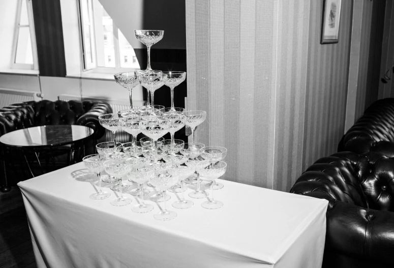 a bunch of wine glasses sitting on top of a table, a black and white photo, martin parr, crystal column, stacked image, decorations