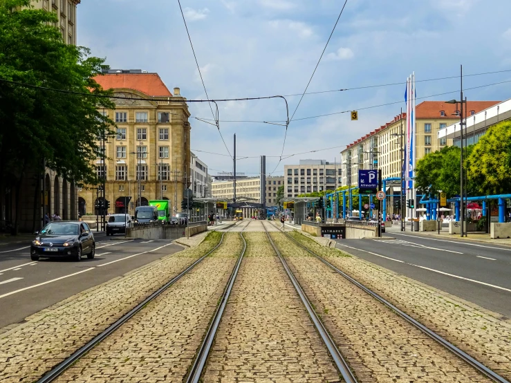 a train track in the middle of a city street, pexels contest winner, berlin secession, square, high resolution photo, wide greenways, unedited