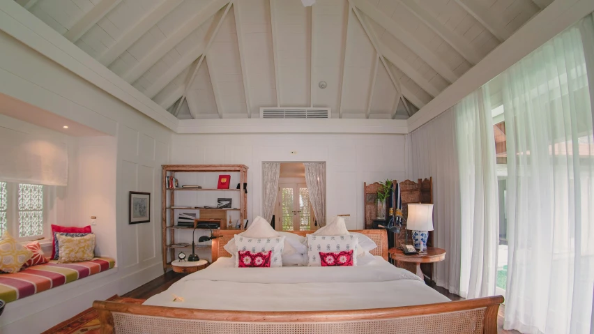 a bedroom with large bed sitting between two windows