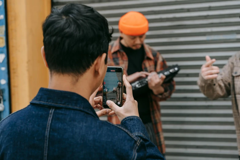 a man taking a picture of another man with a cell phone, trending on pexels, visual art, holding electric guitars, trending on r/streetwear, long distance photo, practice