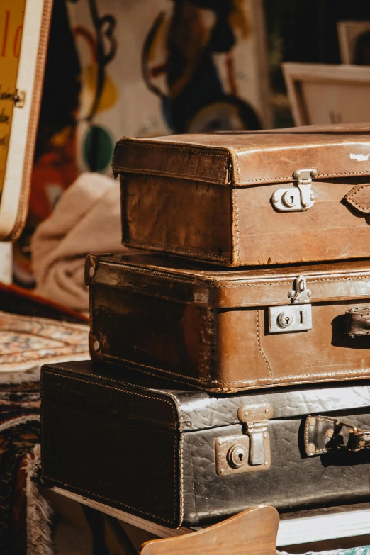 a stack of luggage sitting on top of a table, an album cover, trending on pexels, modernism, antiques, brown, cinematic still, film photo