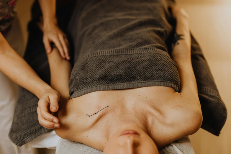 a man laying on top of a bed next to a woman, by Emma Andijewska, trending on pexels, renaissance, acupuncture treatment, scales covering her chest, marked muscles, manuka