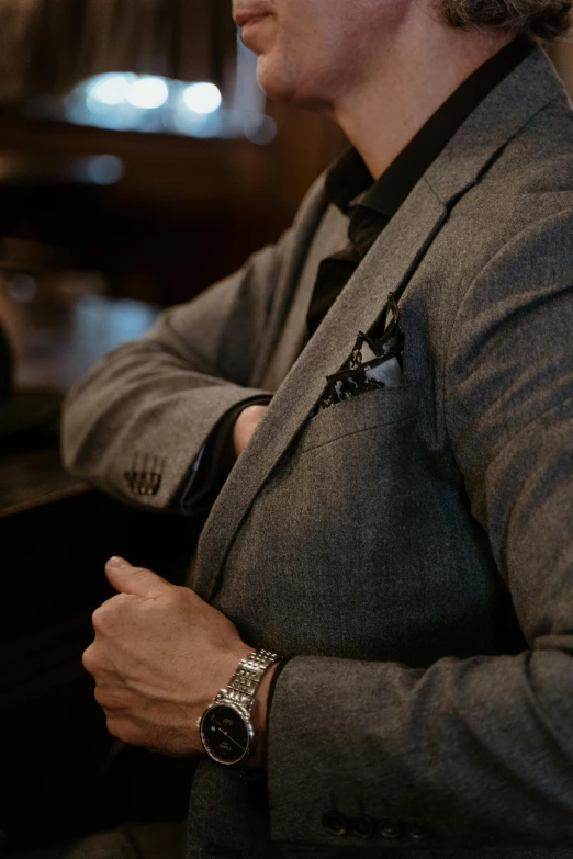 a close - up of a person wearing a suit and watch