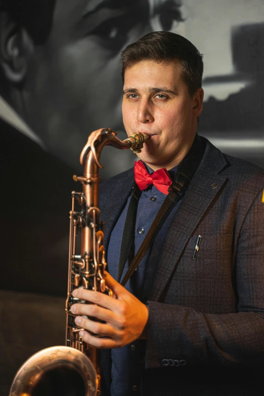 a man wearing a red bow tie playing the saxophone