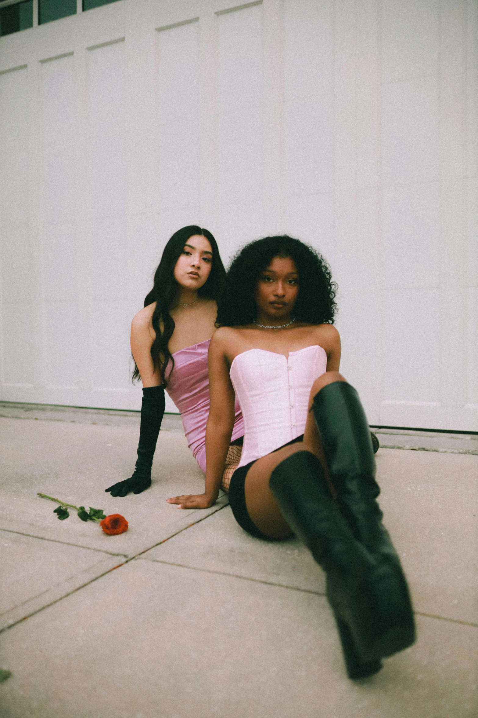 two girls are sitting down on the ground