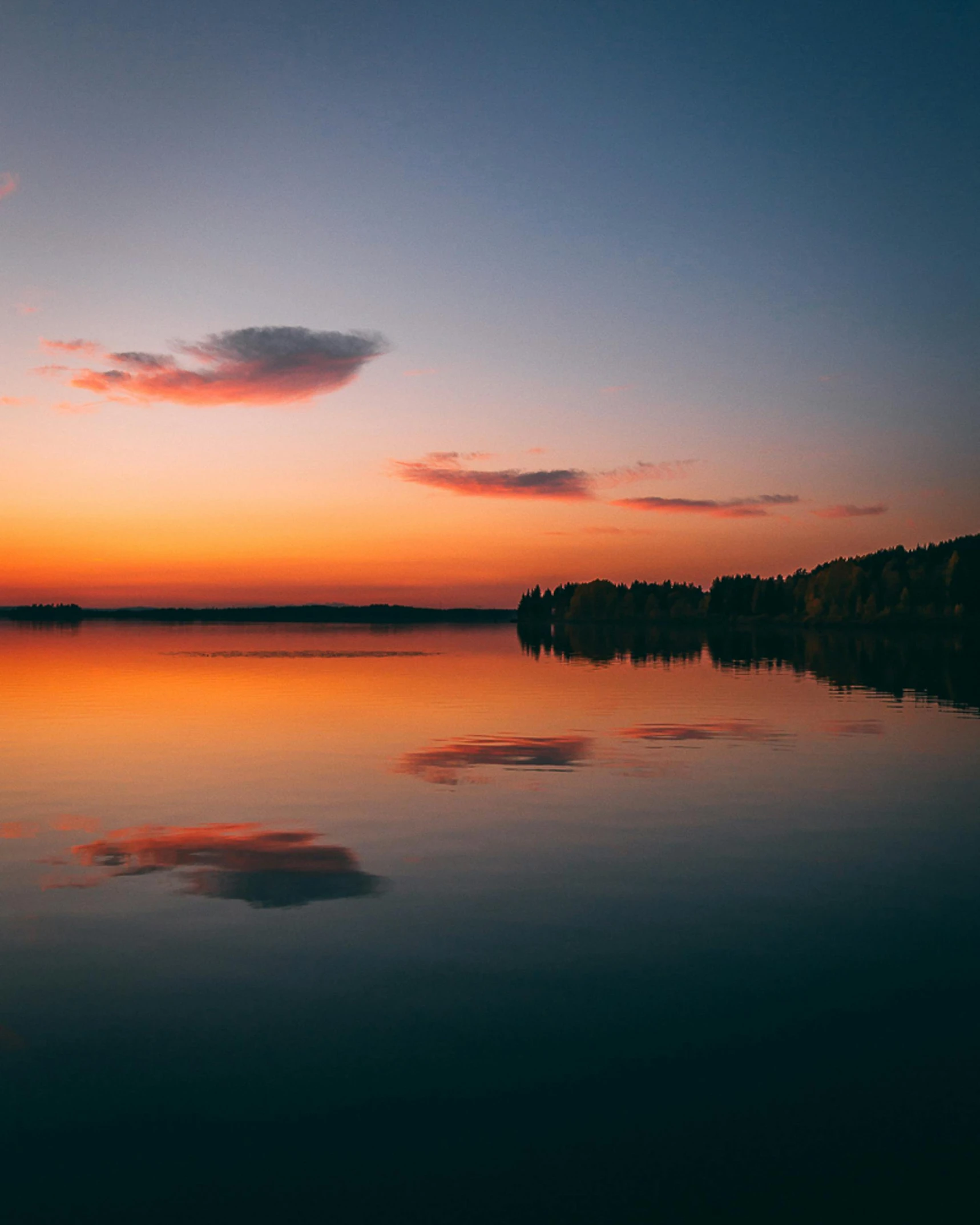 a large body of water with a sunset in the background, by Sebastian Spreng, on the calm lake, helsinki, perfect photo